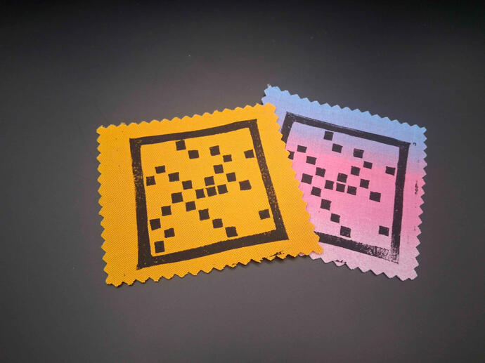 prime spiral Block printed patches of squares in a grid pattern with only the ones representing prime numbers shaded in a spiral (and the number one-- please forgive me).