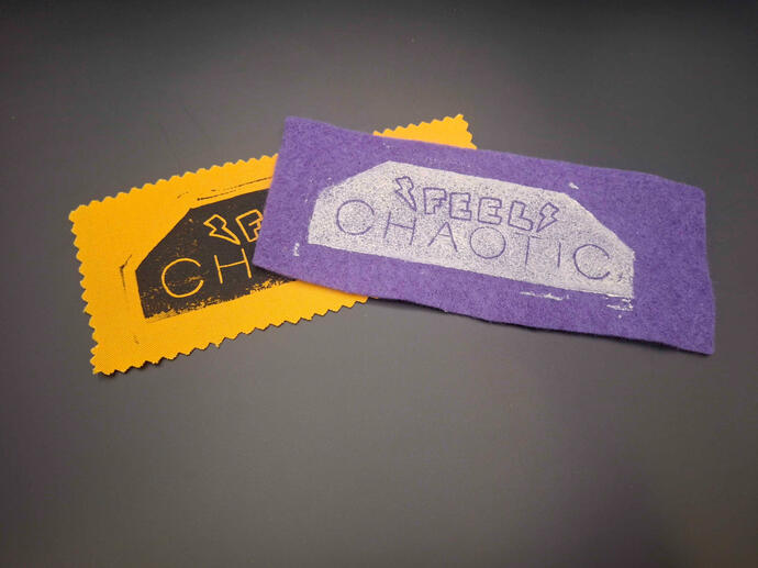 Block printed patches of the words "feel chaotic" with lightning bolts on a solid background.